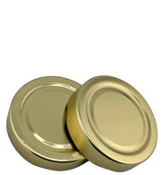 Deux couvercles Twist-Off 82 mm dorés pour bocaux en verre, vue rapprochée.